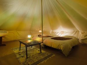 a bedroom with two beds and a table in a tent at Yamamizuki in Shimanto