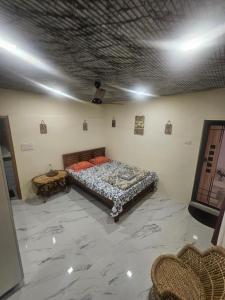 a bedroom with a bed and a table in a room at Richard's Homestay -Classy AC Rooms in Thiruvalla