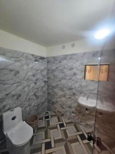 a bathroom with a toilet and a sink at Richard's Homestay -Classy AC Rooms in Thiruvalla