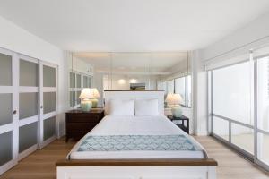 a bedroom with a large bed and two lamps at Ilikai Tower 1936 condo in Honolulu