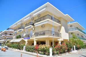 a large yellow building with balconies on a street at Apartments Kalina in Leptokarya