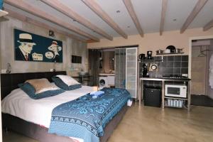 a bedroom with a large bed and a kitchen at Vakantie Studio Grou in Grou