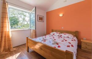 a bedroom with a bed with orange walls and a window at Stunning Home In Peruski in Peruški