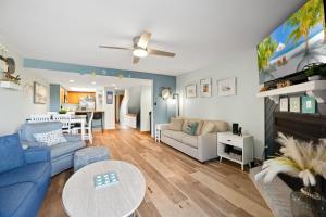 a living room with a blue couch and a table at QCB5 - Saltaire Sunrise in Nags Head
