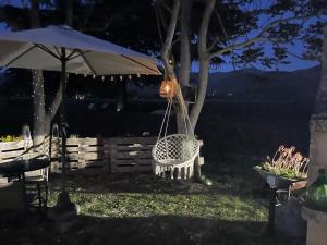 a swing hanging from a tree with an umbrella at Cuore di Legno Country House in Spoleto