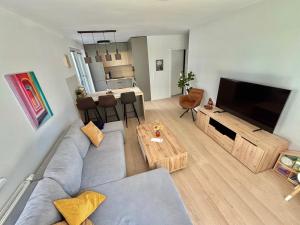 a living room with a gray couch and a table at Stylish Chill Garden Apartment in Bratislava