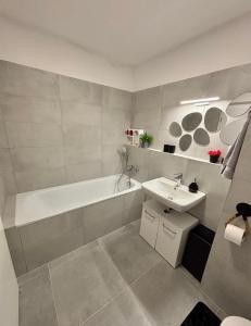 a bathroom with a tub and a sink and a bath tub at Stylish Chill Garden Apartment in Bratislava +21 photos