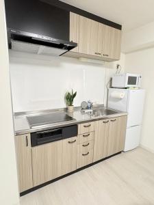 a kitchen with a sink and a refrigerator at カリエンテ三宮202 in Kobe