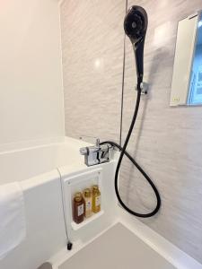 a bathroom with a shower with a hose at カリエンテ三宮202 in Kobe