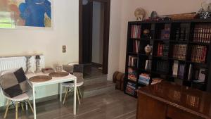 a room with a table and a book shelf with books at Elis studio luxury apartment in Ierapetra