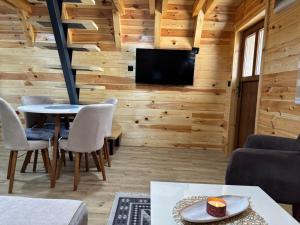 a living room with wooden walls and a table and chairs at Masha in Žabljak