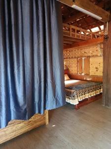 a stage with a blue curtain in a room at A Vũ Homestay & Coffee in Kon Cho Dri