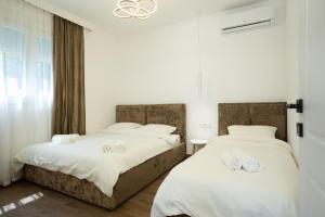 two beds sitting next to each other in a bedroom at Villa Hoxha 80 in Durrës +119 photos