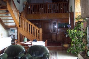 a living room with a staircase and a table and chairs at villa Périgord in Monteton