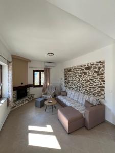 a living room with a couch and a stone wall at Athanasia's Eremion in Zagora