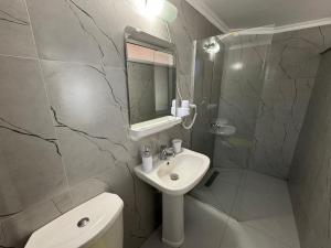 a bathroom with a sink and a toilet and a mirror at Rexhos Studios in Himare +204 photos