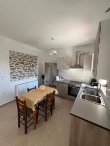 a kitchen with a table and chairs and a kitchen with a sink at Athanasia's Eremion in Zagora