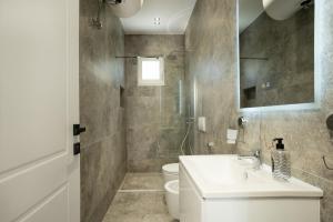 a bathroom with a sink and a toilet at Villa Hoxha 80 in Durrës