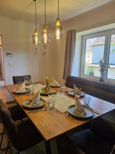 a wooden table with plates and napkins on it at Dreimäderlhof Ferienhaus in Karlstetten +21 photos