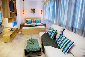 ein Wohnzimmer mit zwei Betten und einer Couch in der Unterkunft Emerald Suite in Athen