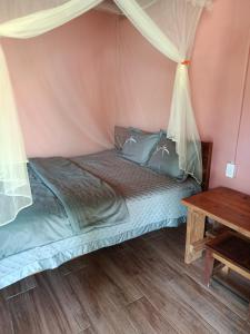 a bed in a tent with a table at A Vũ Homestay & Coffee in Kon Cho Dri