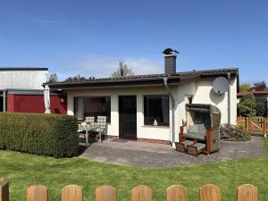 a small white house with a table and chairs at SielundMeer in Neuharlingersiel