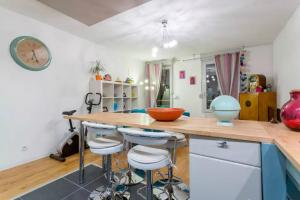 eine Küche mit einer Theke und Hockern in einem Zimmer in der Unterkunft Appt T3, 55m2 proche Parc Tête D'or et quais du Rhône in Caluire-et-Cuire