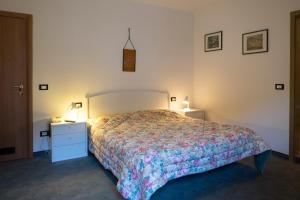 a bedroom with a bed and two night stands and two lamps at Albergo Alpino in Falcade