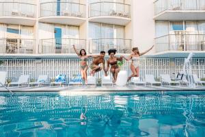 a group of people jumping into a swimming pool at OUTRIGGER Waikiki Paradise Hotel in Honolulu +100 photos