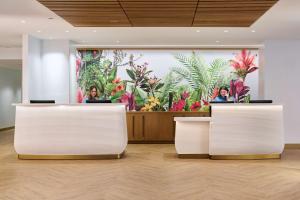 two women sitting at the reception desks in a lobby at OUTRIGGER Waikiki Paradise Hotel in Honolulu
