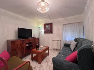 a living room with a couch and a tv at A casa do teléfono in Pumares