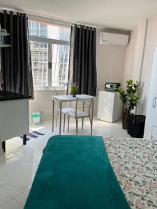 a living room with a table and a green rug at Tropical Loft in Niterói +9 photos