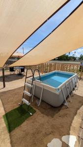 a hot tub and a chair under a large umbrella at Zulis Haven Stay in Kuala Rompin