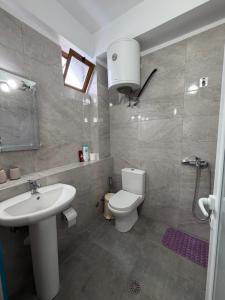 a bathroom with a white sink and a toilet at Villa Earta & Leo Ksamil in Ksamil +46 photos