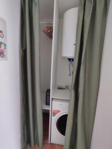 a laundry room with a washing machine and a green curtain at GuestHouse Tana del Riccio Todi in Todi +8 photos