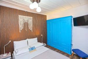 a bedroom with a blue door and a bed at Plomari Nest in Plomari