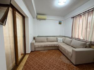 a living room with a couch and a television at Villa Earta & Leo Ksamil in Ksamil