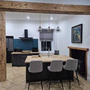 a kitchen with a kitchen island with chairs and a sink at Lochmaben in Lochmaben
