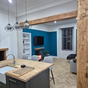 a kitchen and living room with blue walls and a fireplace at Lochmaben in Lochmaben