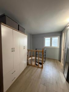 an empty room with a large white cabinet and wooden floors at KingsWay Mezzanine in Ágios Rókkos