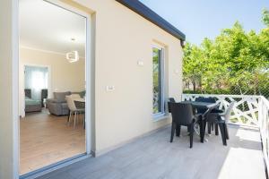 a sliding glass door leading to a patio with a table and chairs at Villa Hoxha 80 in Durrës