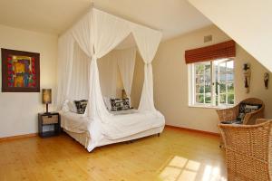 una camera da letto con un letto a baldacchino di Cape Paradise Lodge and Apartments a Città del Capo Altre 48 foto