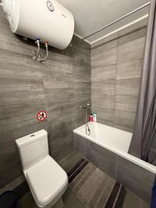 a bathroom with a toilet and a bath tub at KingsWay Mezzanine in Ágios Rókkos +10 photos