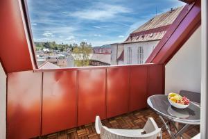 a balcony with a table and chairs and a window at Mestský Hotel Ďumbier in Brezno