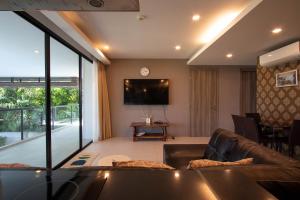 a living room with a couch and a flat screen tv at Escape Condominium By A property in Mae Pim