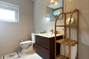 a bathroom with a sink and a toilet and a mirror at Ferienwohnung Frangipani in Utjeha +3 photos