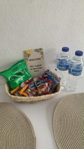 a basket of snacks and water bottles on a table at Lemon Luxury Studio in Xanthi