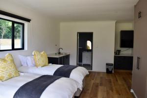 a bedroom with two white beds and a television at Mable's BnB in Retreat