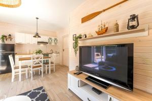 a living room with a large flat screen tv at Domek -Tiny House Resort Marino in Grzybowo