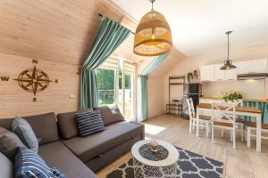 a living room with a couch and a table at Domek -Tiny House Resort Marino in Grzybowo